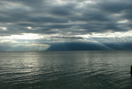Association pour la sauvegarde du Léman Photo du Léman sous un ciel couvert à travers lequel les rayons du soleil passent.