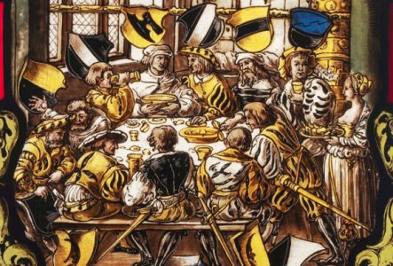 © Atelier Girardet Vitrail représentant un festin médiéval : on y voit des hommes autour du table en train de manger et de boire. Il y a une dominance de jaune et de noir.