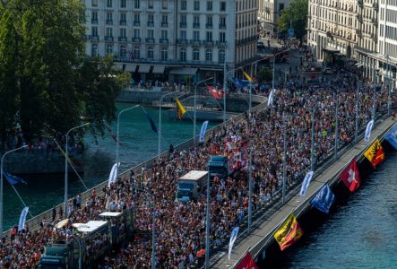DR Sur cette image on peut voir une foule de personnes allant sur le pont du mont blanc à Genève. Au milieu de la foule on remarque des bus qui diffuse de la musique.