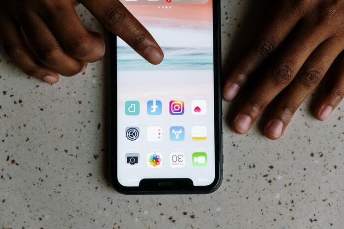 Les mains d'une personne pianotent sur un smartphone