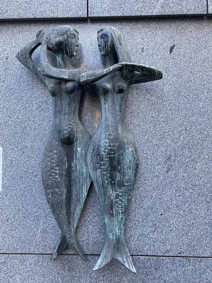 deux statue de sirènes fixer au mur