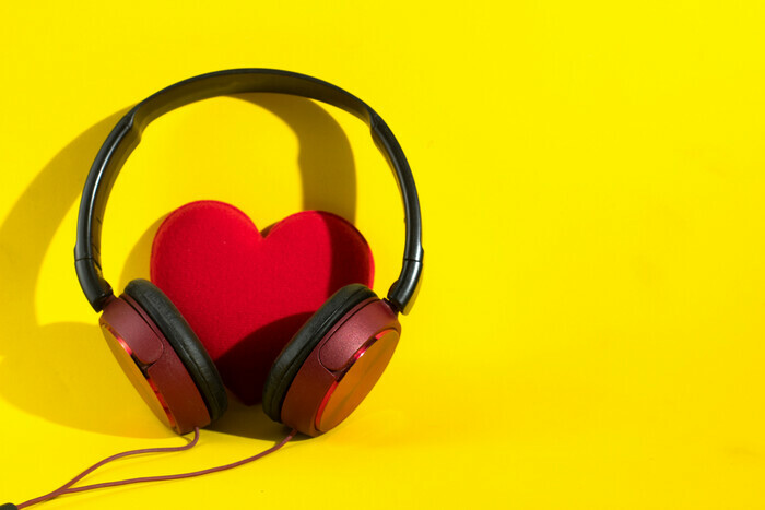 Un casque audio entoure un coeur rouge en feutrine