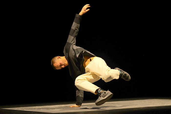 un danseur hip hop au sol en équilibre sur une main