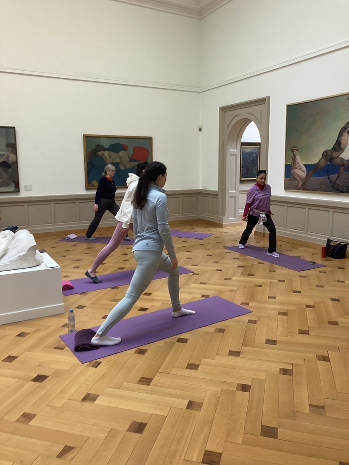 Groupe de personnes faisant du sport dans une salle du musée