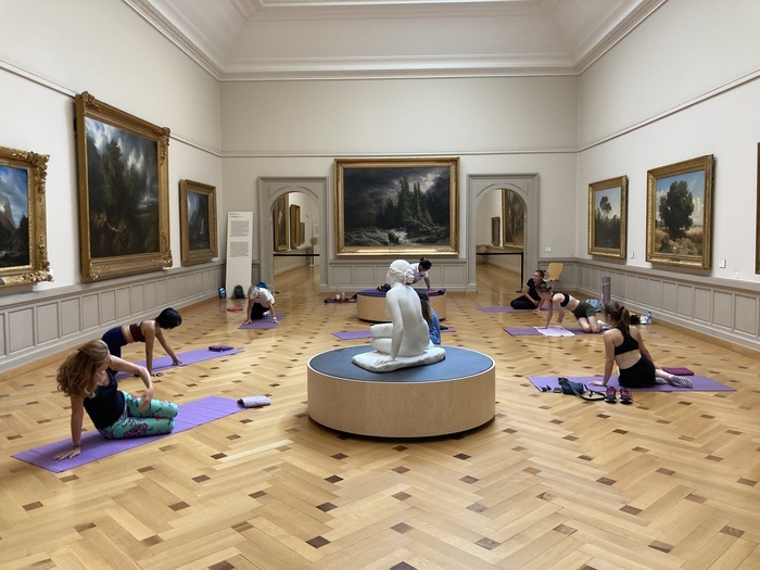 Groupe de personnes faisant du sport dans une salle du musée