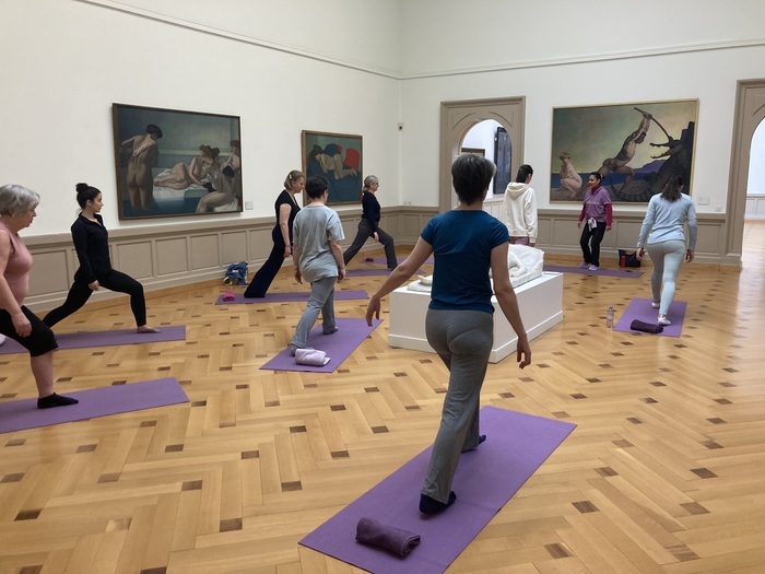 Groupe de personnes faisant du sport dans une salle du musée