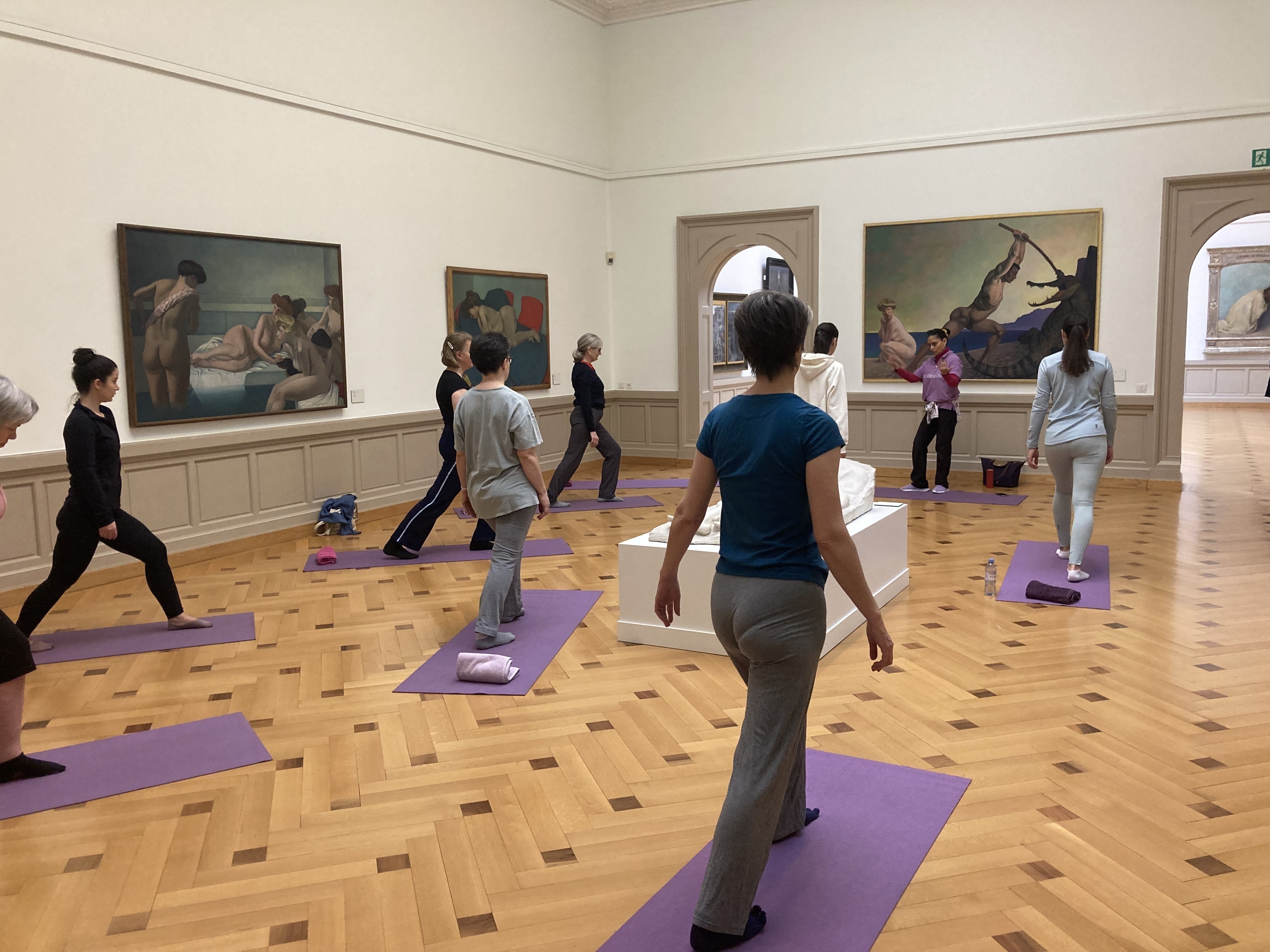 Groupe de personnes faisant du sport dans une salle du musée