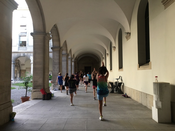 Groupe de personnes faisant du sport dans la cour du musée