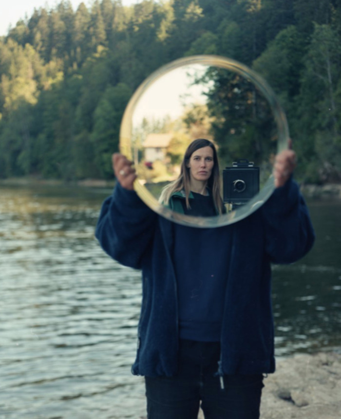 Camille devant un lac en se regardant dans un miroir