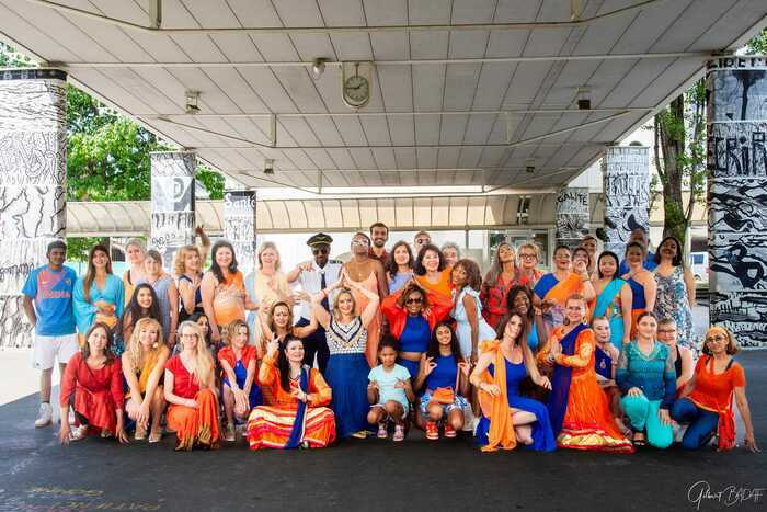 Un groupe de personnes qui danse bollywood en costumes coloré