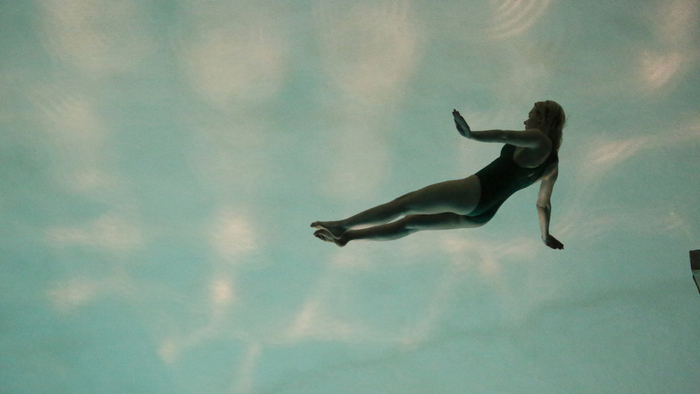 Une femme flotte sous la surface de l'eau.