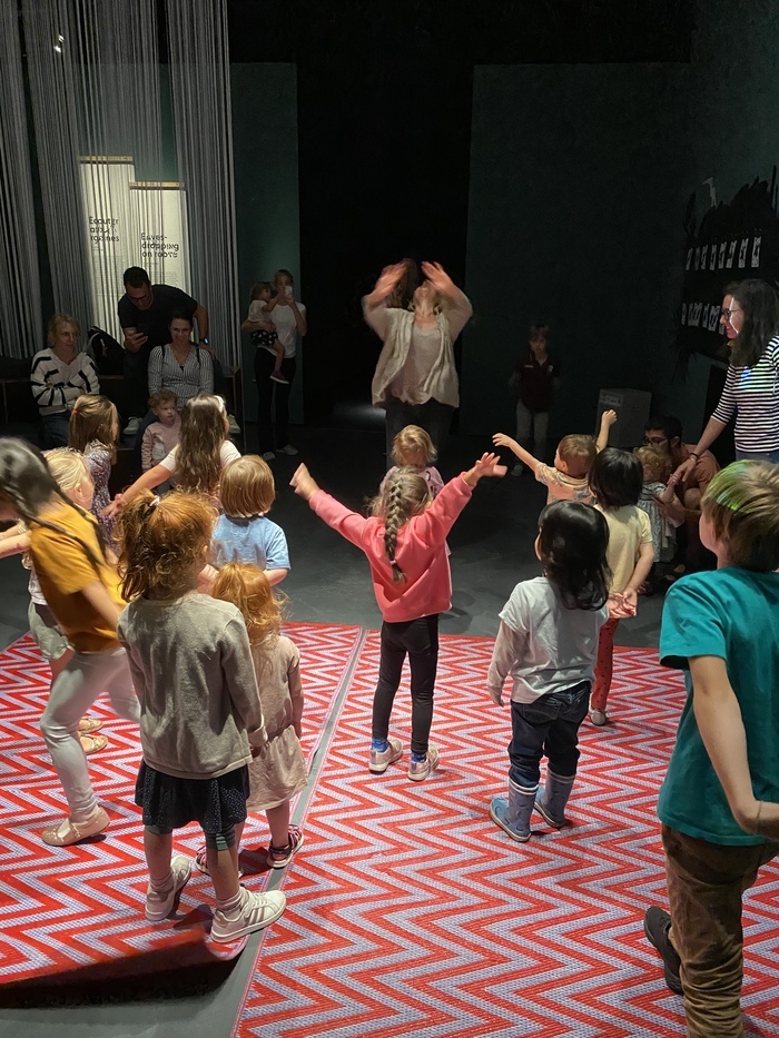 Des enfants imitent les gestes d'une animatrice dans une exposition du MEG à Genève