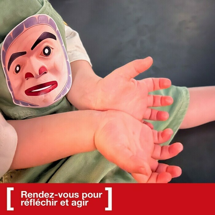 Les paumes des mains d'un enfant qui a un autocollant collé sur son habit. cet autocollant représente le masque d'un prince.