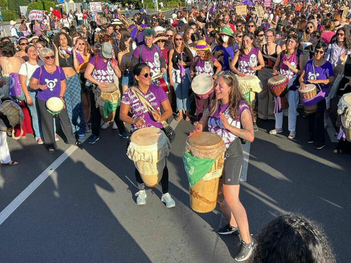 Une photo en couleur qui représente des femmes qui jouent sur différents instruments de percussion.