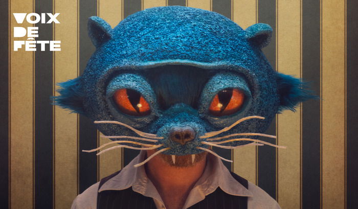 Photo de l'artiste avec un masque de chat bleu et de grands yeux oranges