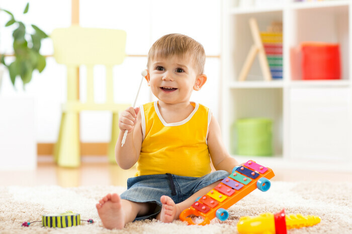 Un très jeune enfant s'amuse avec des instruments de musique