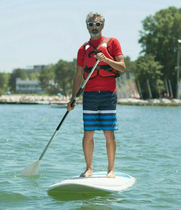 Senior faisant du paddle sur le lac