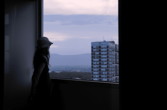 Une femme regarde le ciel à travers la fenêtre