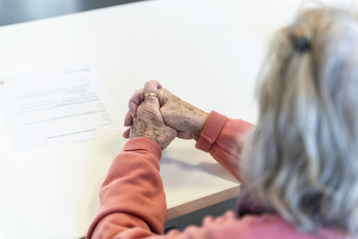 une dame est assise devant une table avec un document devant elle