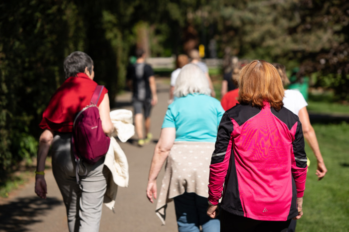 PLUSIEURS PERSONNES MARCHANT DANS UN PARC