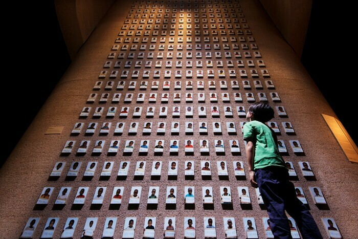 Enfant se tenant devant une œuvre de l'exposition permanente