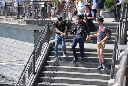 Un comédien de la troupe des Balades Théâtralisées jouant le personnage de l'anarchiste Lucheni, assassin de l'impératrice Sissi, descend des marches. Il est enchaîné et encadré par deux spectateurs coiffés d'un képi de gendarme. La guide et les spectateurs les suivent.