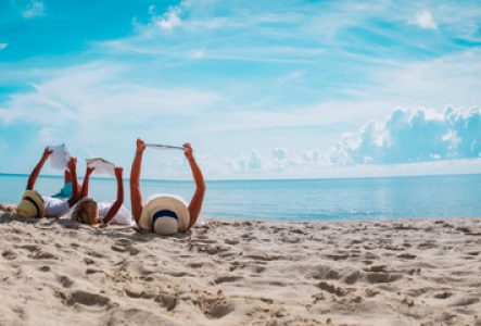 Une famille lit des livres à la plage