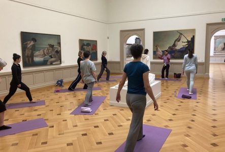 Groupe de personnes faisant du sport dans une salle du musée