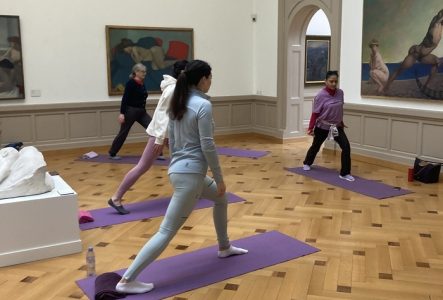 Groupe de personnes faisant du sport dans une salle du musée