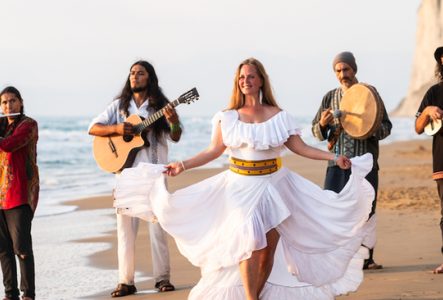 Les membres du groupe marche sur une plage en jouant de leurs instruments