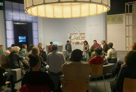 Discussion au salon de l'exposition au MEG: Mémoires. Genève dans le monde colonial. Des personnes sont assises et discutent.