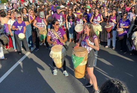 Une photo en couleur qui représente des femmes qui jouent sur différents instruments de percussion.