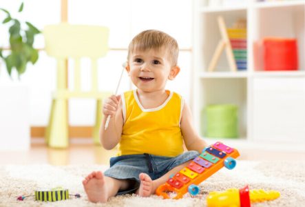 Un très jeune enfant s'amuse avec des instruments de musique