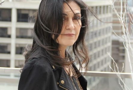 Rana Farhan, les cheveux dans le vent, sur fond urbain