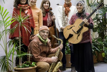 Le groupe vêtu de tons orangés au milieu des plantes vertes